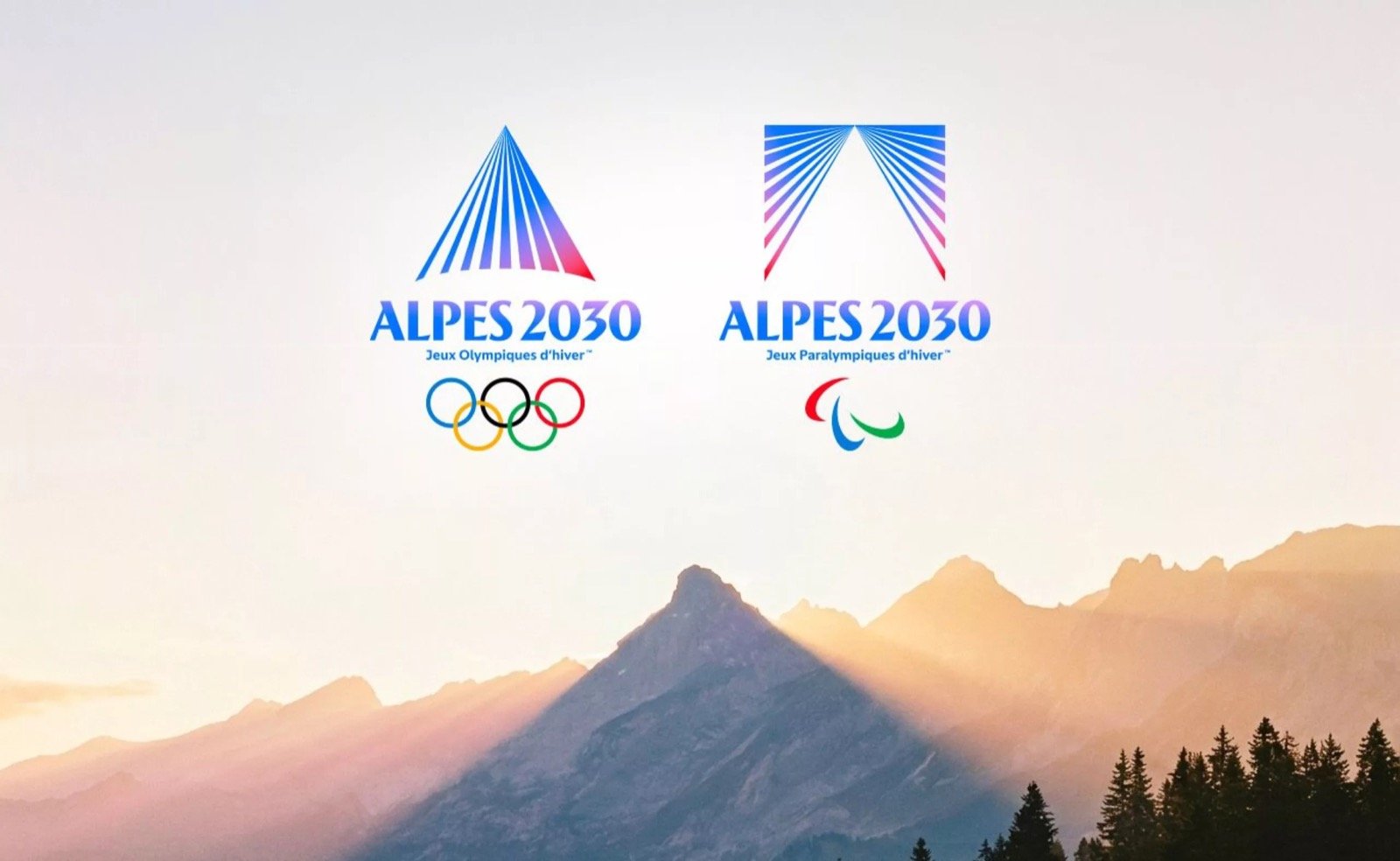 Les emblèmes olympique et paralympique d'Alpes 2030 au-dessus des sommets en lumière alpenglow